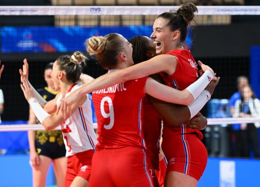 French volleyball players celebrating a point on the court.